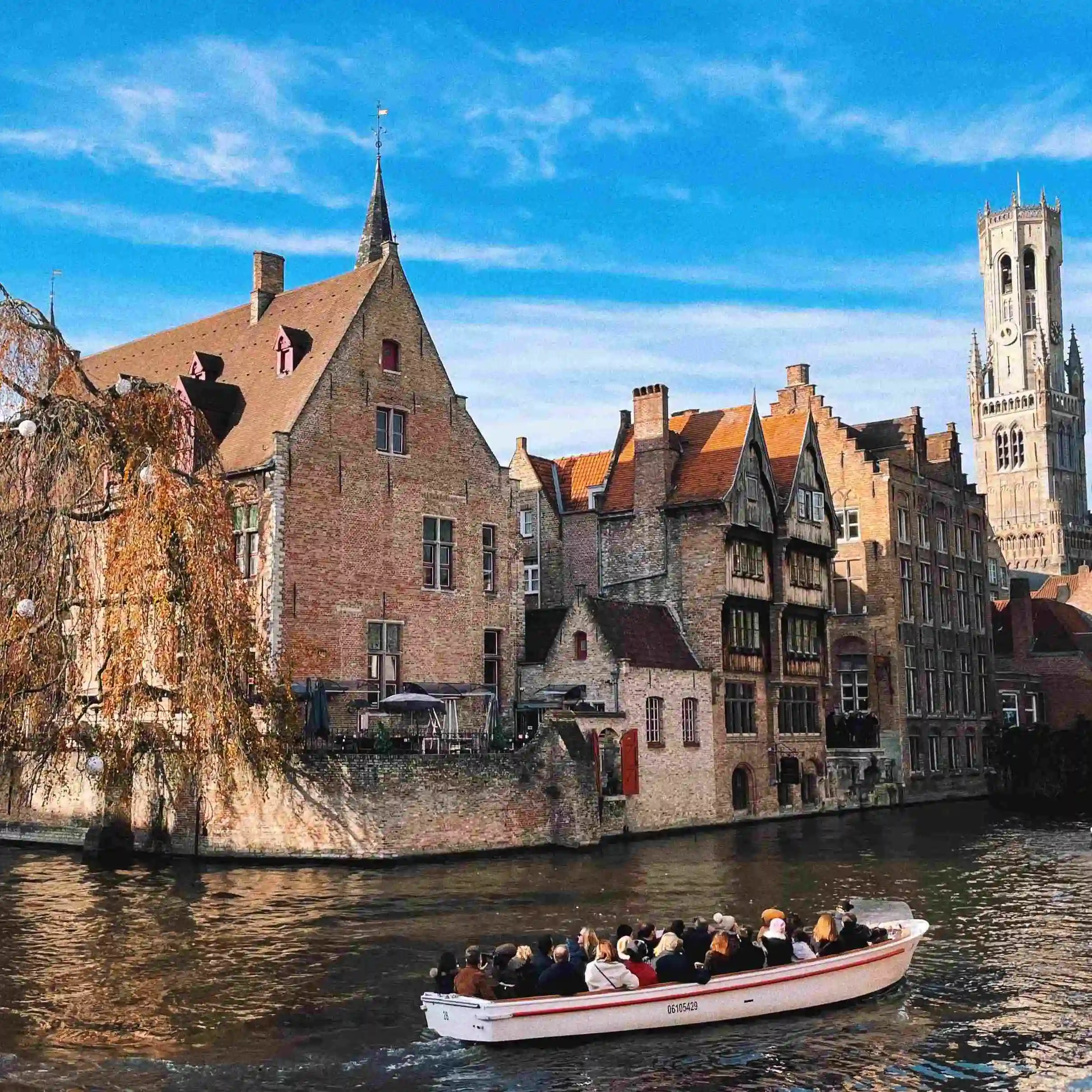 Vistas del canal de Brujas con una barca llena de gente