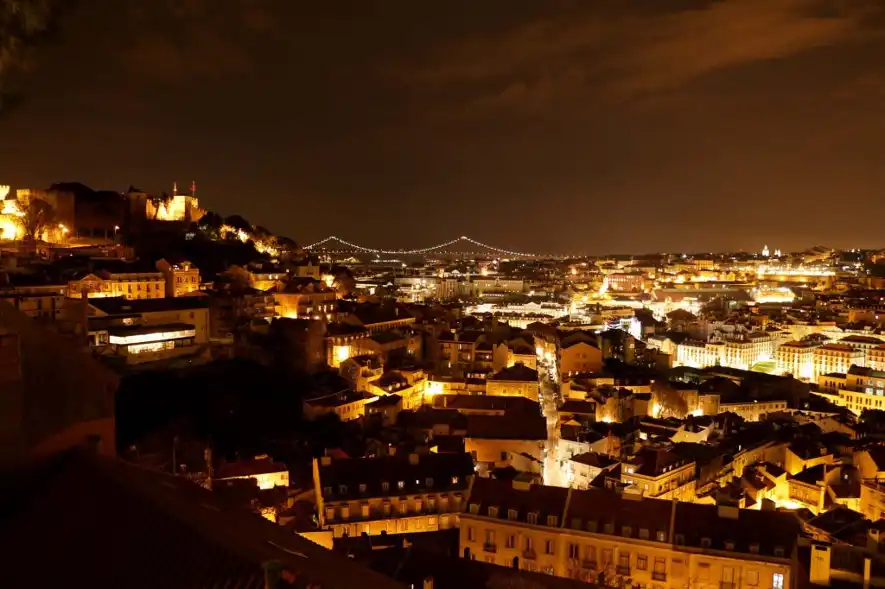 Vistas de Lisboa de noche desde el Mirador de Santa Lucia con todos los edificios y calles iluminados.