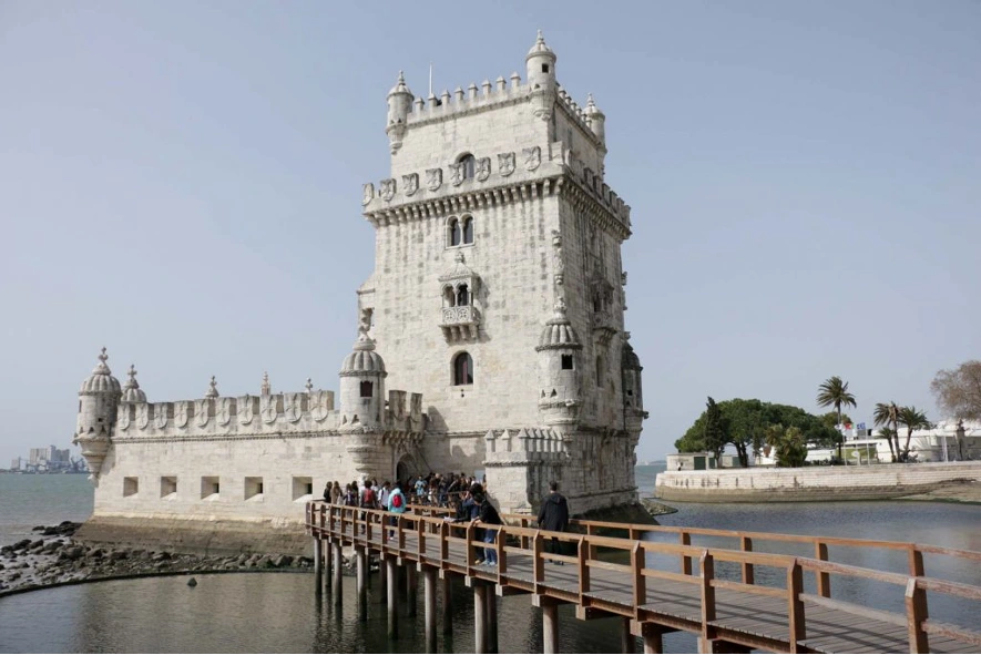 La Torre de Belem con la pasarela de madera para entrar a visitarla llena de turistas en Lisboa.